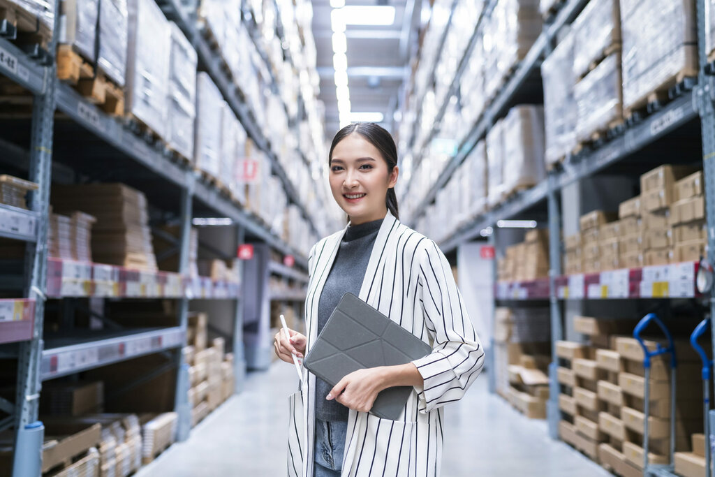 Portrait of asian woman business owner using digital tablet checking amount of stock product inventory on shelf at distribution warehouse factory.logistic business shipping and delivery service